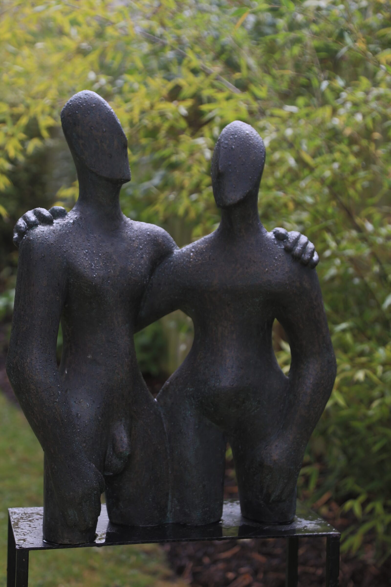 contemporary bronze sculpture of a couple in the garden