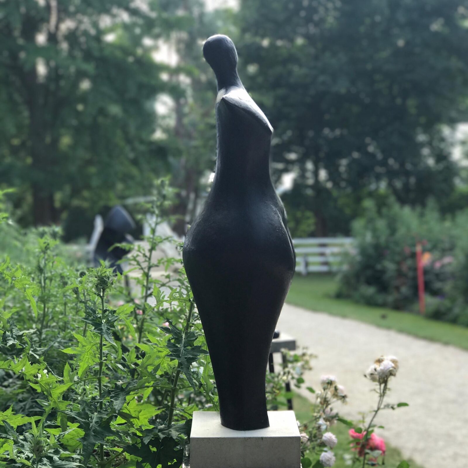 contemporary bronze figurative sculptures in a rose garden