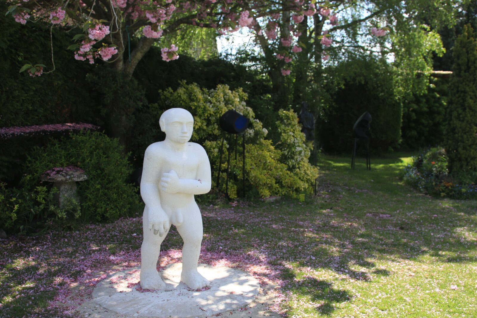 modern stone sculpture of a man in the garden