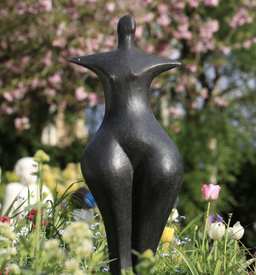 contemporary bronze sculpture of a figure installed in the garden