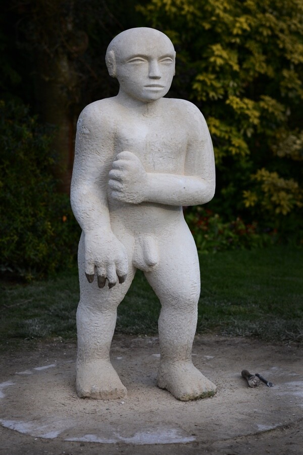 Unfinished modern Lime stone sculpture of a nude man in the process of walking forward