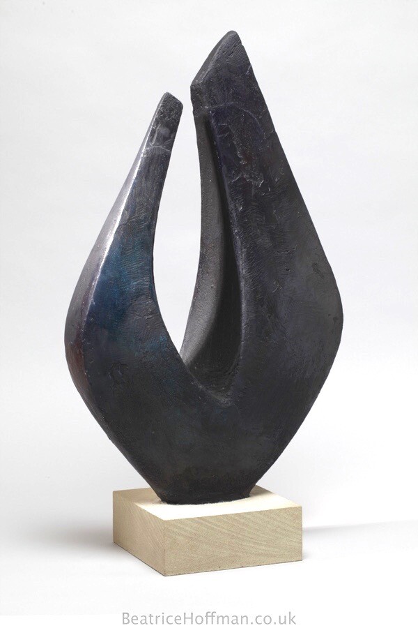 Geometric abstract blue sculpture of two sides encompassing a negative shape