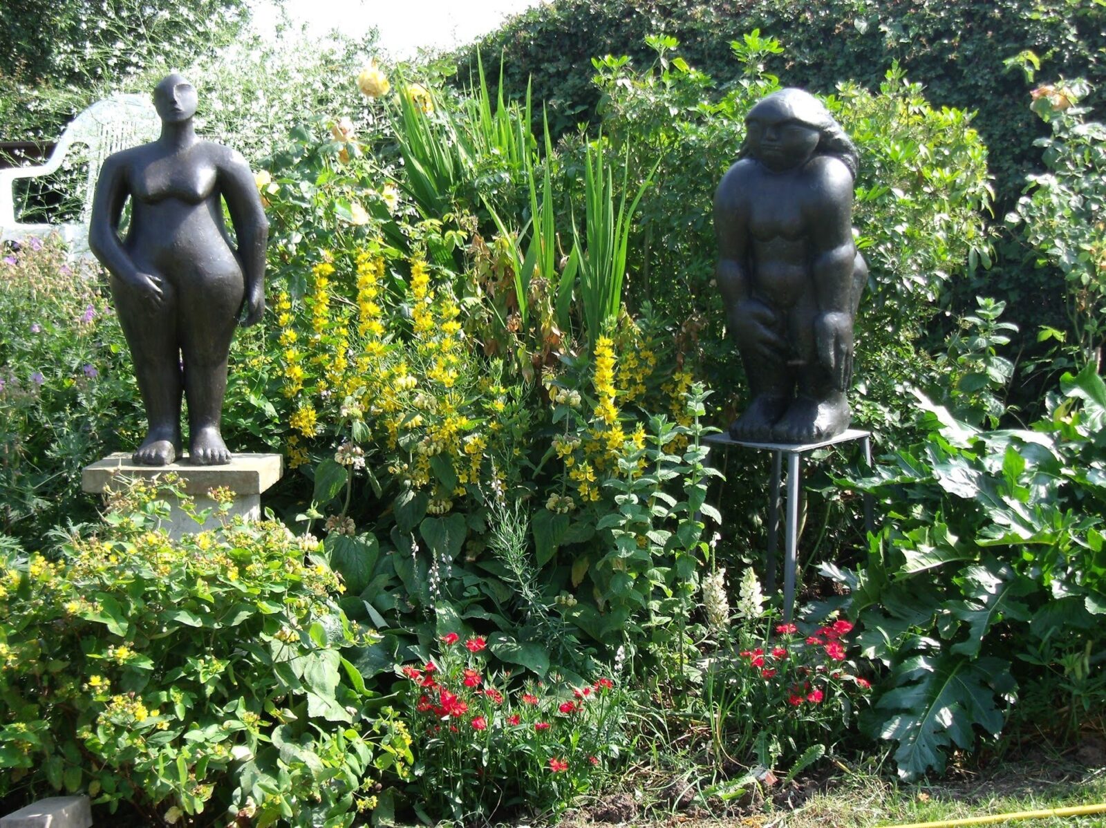 modern bronze sculpture of a compact female figure in the garden