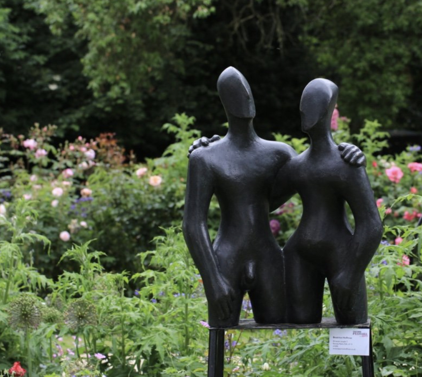 Contemporary bronze sculpture of a couple in the rose garden