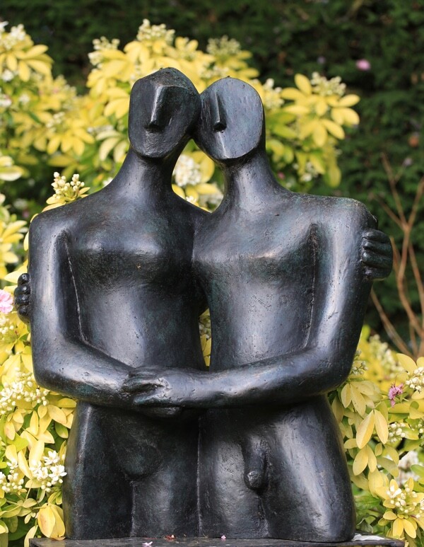 Contemporary bronze sculpture of a tender couple in the garden
