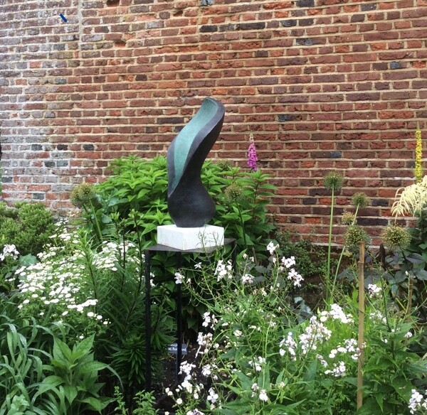 Contemporary abstract floral bronze sculpture in the garden border