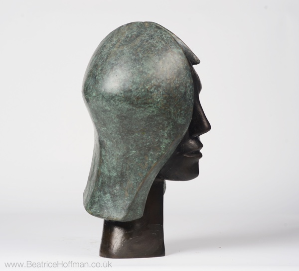 contemporary bronze sculpture of a head in green and black